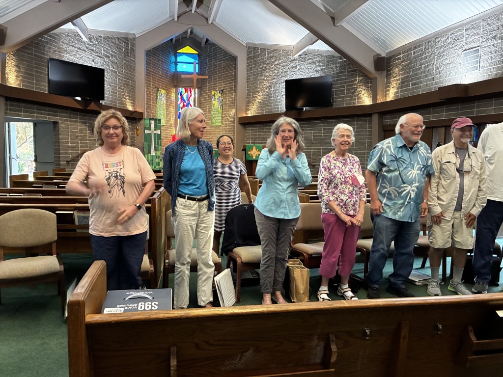 Chorus members rehearsing together in the church sanctuary